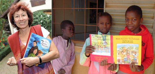 Sylvia Schopf und drei afrikanische Kinder, die ihr Umdrehbilderbuch „Marie hat jetzt Stachelzöpfe“ halten.